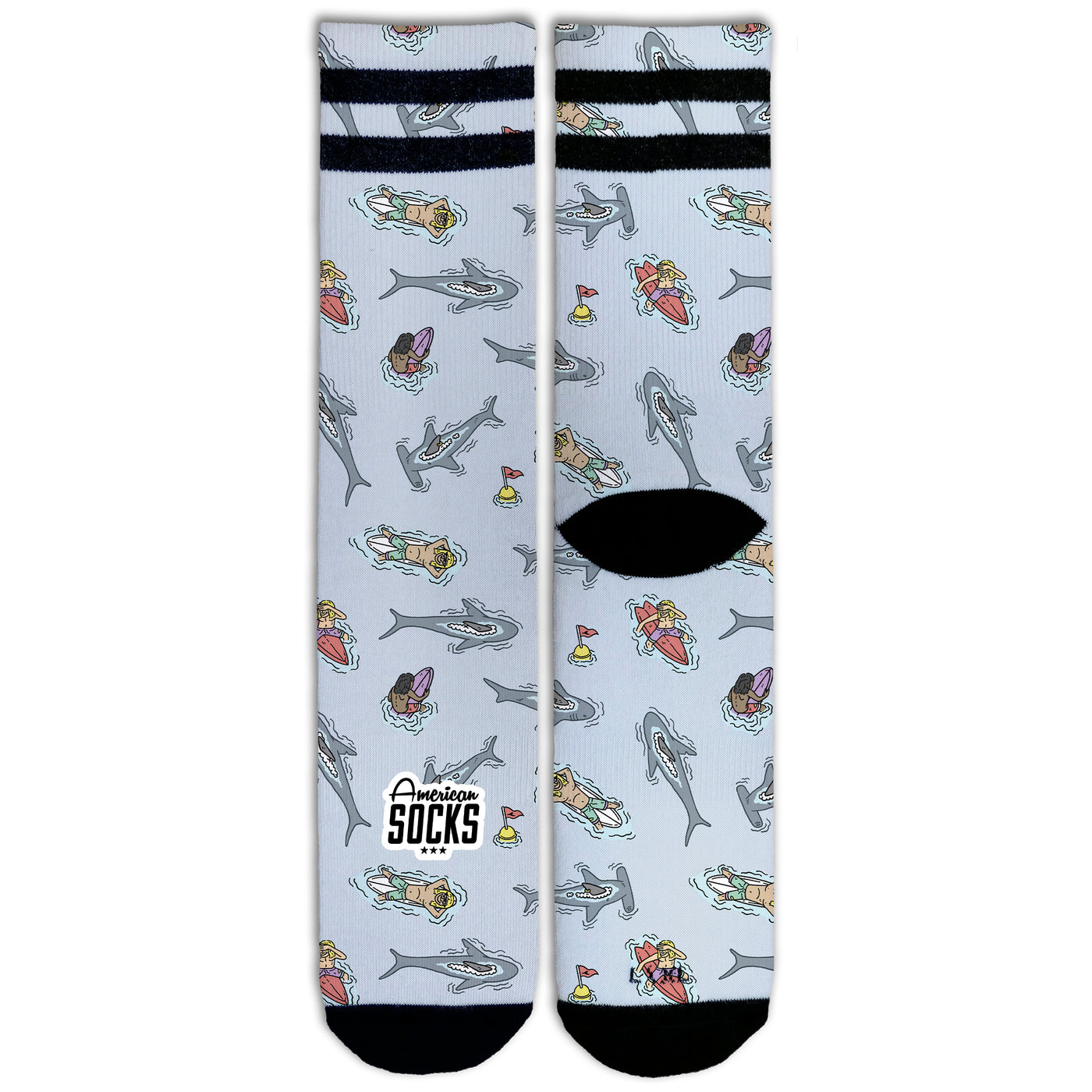 Front view of fun sea themed socks with characters floating on surfboards surrounded by sharks by american socks 