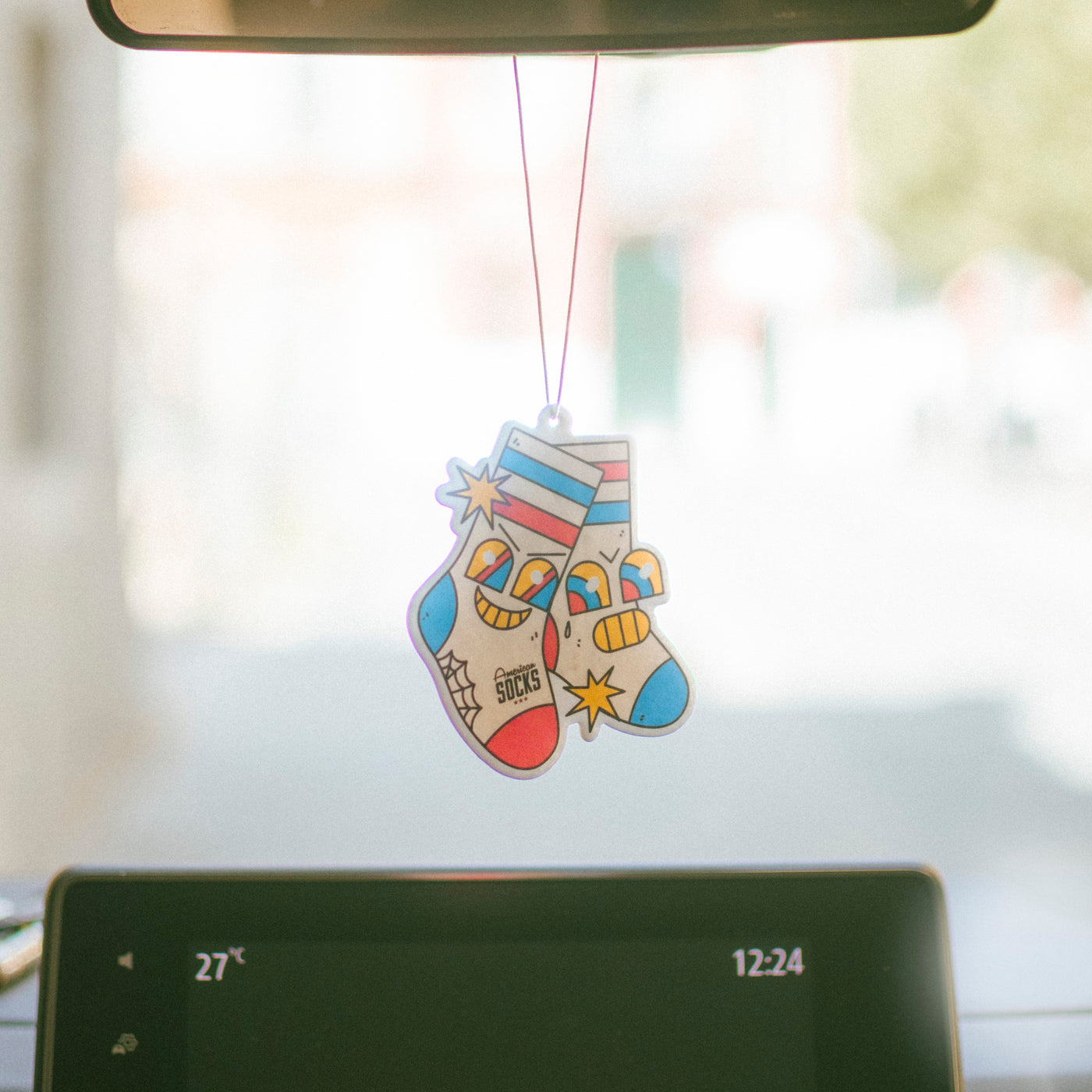 Colorful sock-shaped air freshener hanging from a car's alternative design