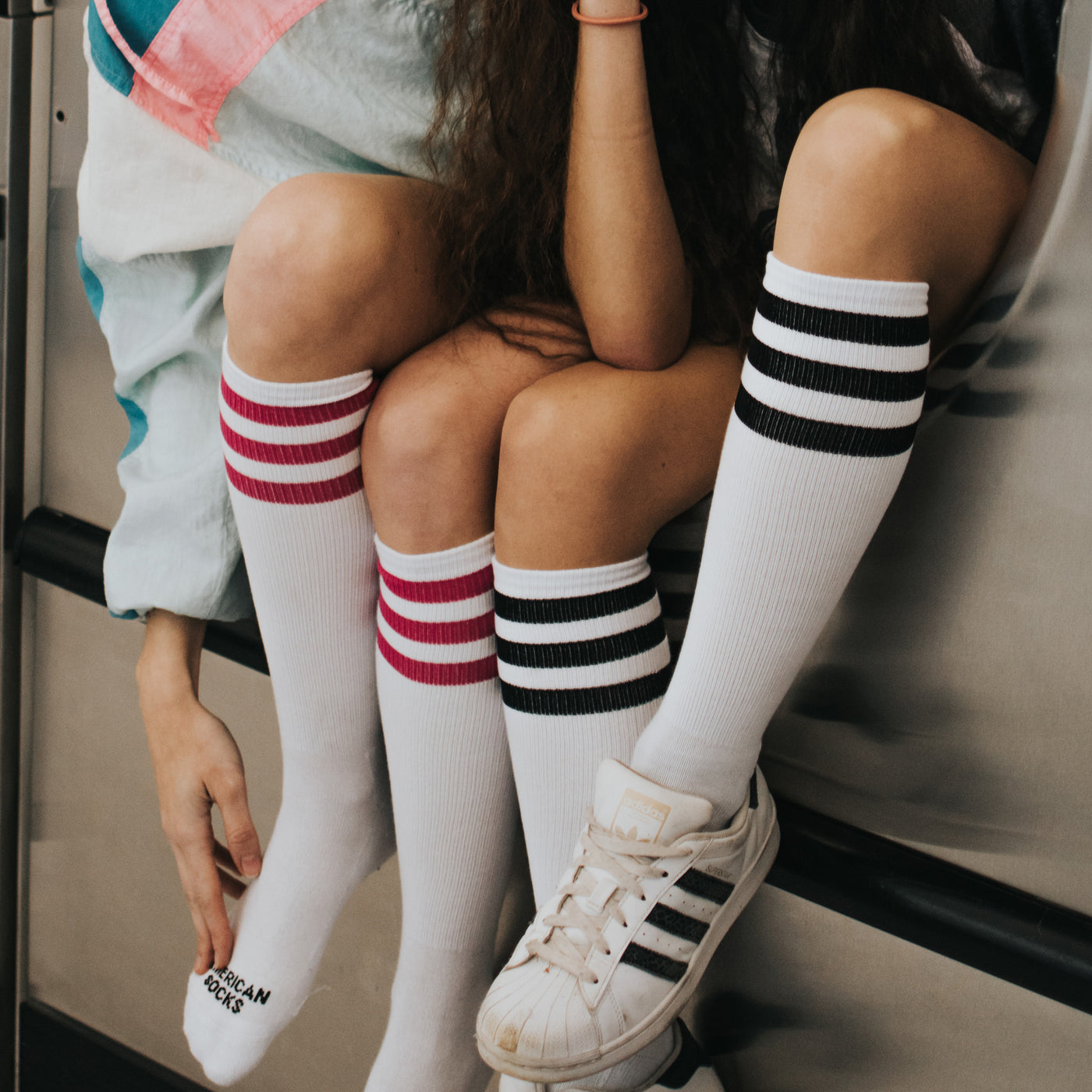 Two legs coming out of washing machine wearing retro striped tube socks american socks