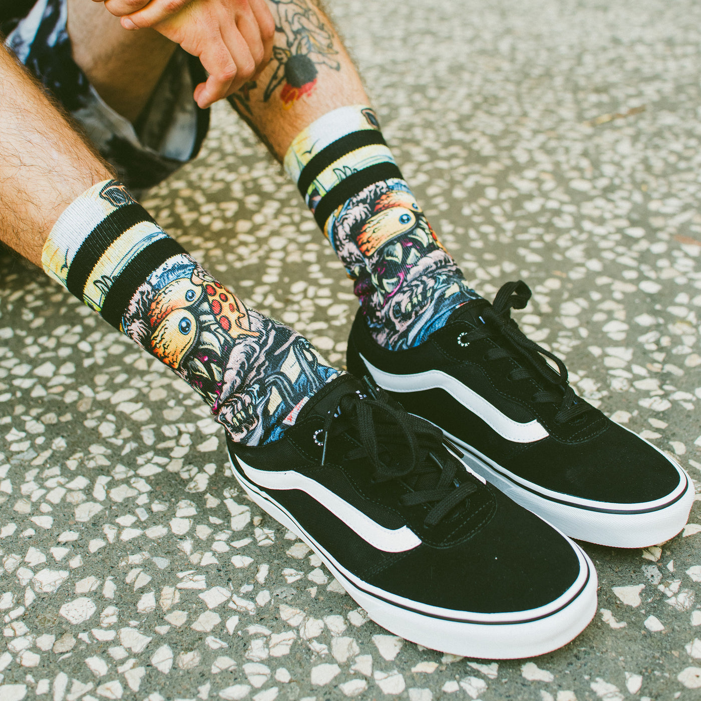 Cool socks with monster eating pizza while riding a bike design worn by person sitting on the ground american socks 